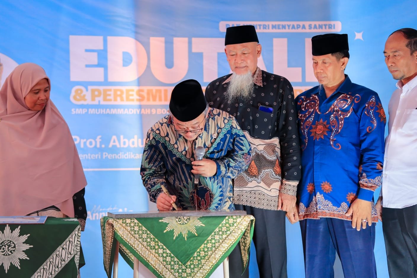 Menteri Pendidikan, Prof. Abdul Mu'ti, M.Ed., didampingi pimpinan Muhammadiyah dan kepala sekolah, sedang melakukan pengguntingan pita saat meresmikan Gedung Terpadu PPM An-Nur Sidoarjo di depan bangunan sekolah yang baru.